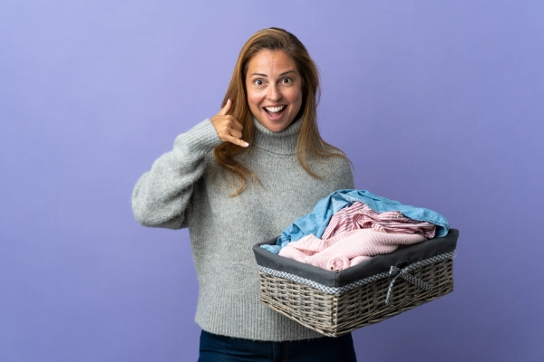 Woman With Laundry Basket Gesturing To Call Her On Purple Background 600X400